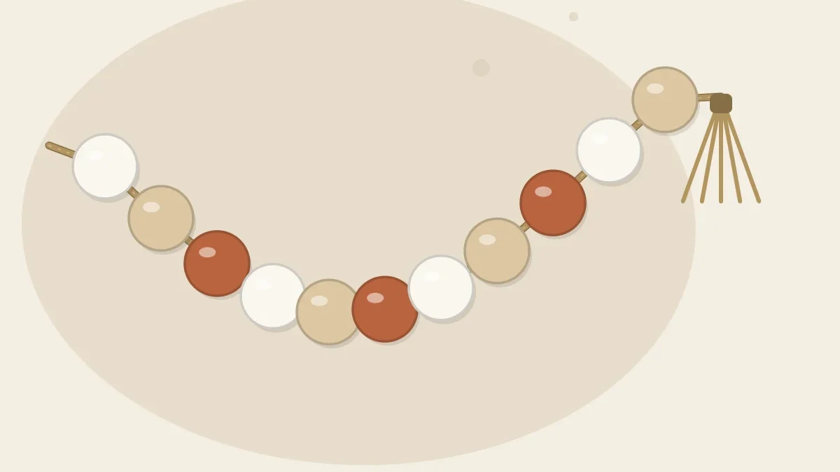 A garland of large round clay beads in white, sand and terracotta strung on jute cord with a tassel at one end, laid in a loose curve