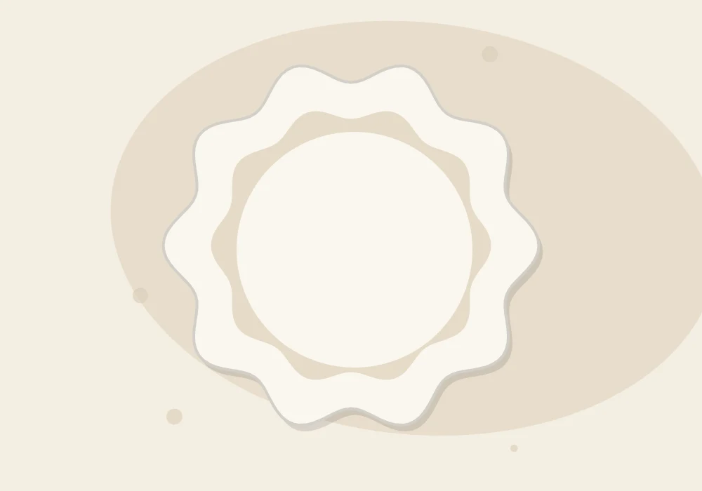 A round clay dish with a softly scalloped, pinched rim before drying, seen from above