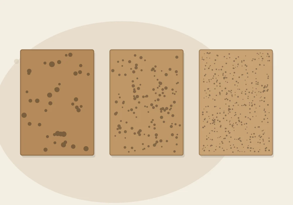 Three sheets of sandpaper in a row going from coarse to fine, shown by speckles that get smaller and denser